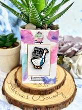 Load image into Gallery viewer, A colorful enamel pin featuring a stylized goose wearing a tie, displayed on a card with 'Today I am a serious Goose' written on it, placed on a wooden surface with a potted plant and the brand name 'Athena's Bounty' visible in the background.